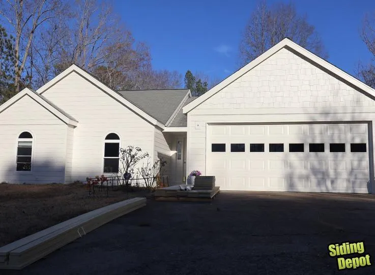 Newly painted white home with two-car garage and shake siding gable