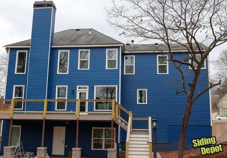 Three-story Canton home with bold blue siding, white trim and rebuilt rear deck