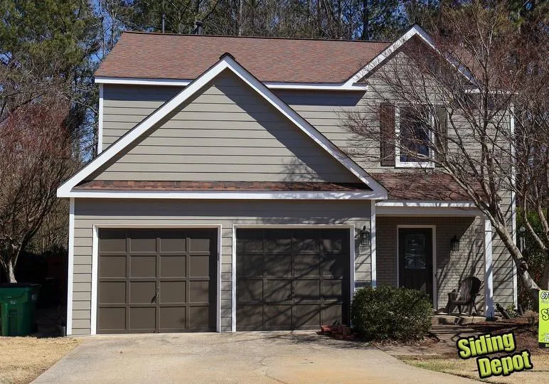 Tan craftsman style home in Roswell with new gables, dark garage doors and roofing