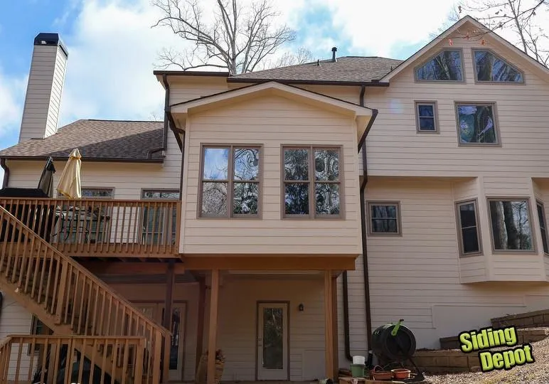 Backyard view of repainted home with new windows and rebuilt wood deck